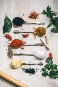 Picture of salt and dried herbs and spices on spoons.