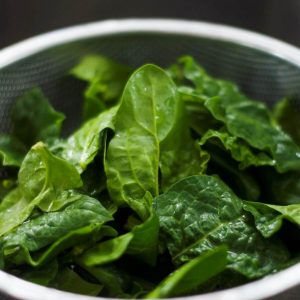 Raw spinach in a colander